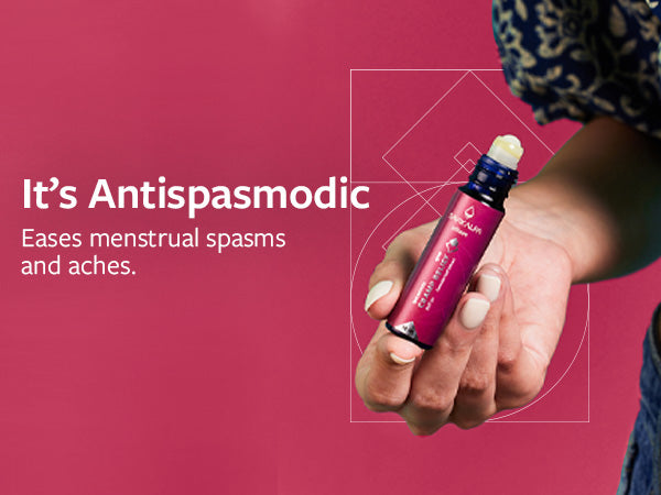 A woman holding Shunyata Cramp Relief in her hand to tackle menstrual spasms and aches using its antispasmodic properties. 