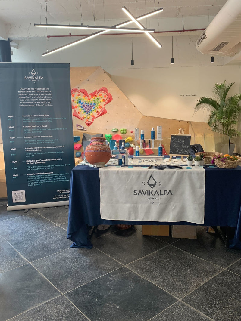 Promotional booth for Savikalpa at Boulder blast competition in a climbing gym displaying products and brochures