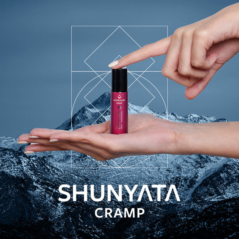 Shunyata Cramp Relief in the hands of a woman set against a snowy mountain top to denote a sense of calmness and peace.